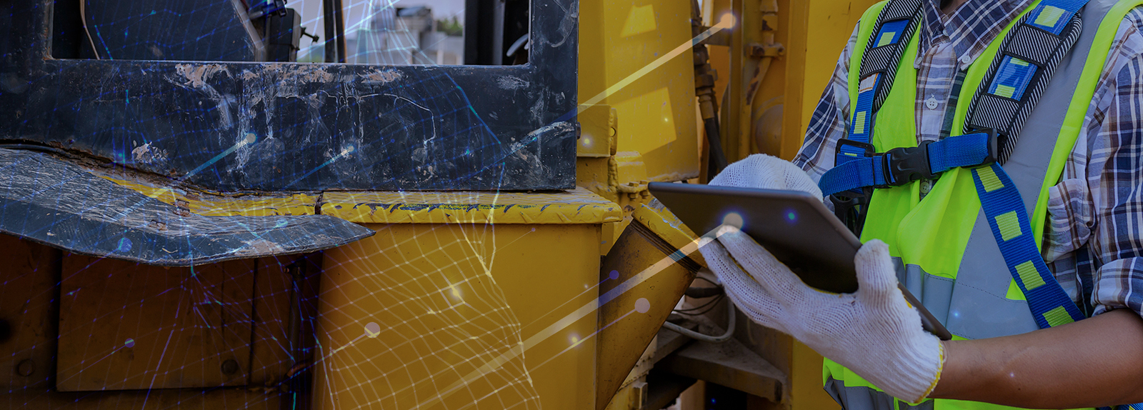 Man with tablet standing next to construction equipment with technology connection overlay